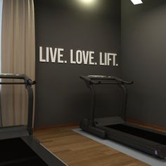 there is a treadmill in front of the wall that says live love lift on it