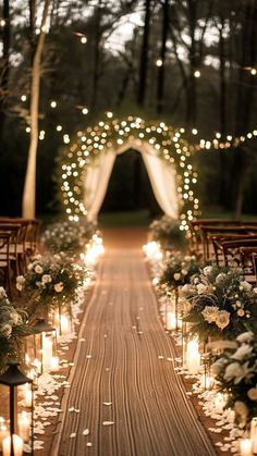 an outdoor ceremony with candles and flowers on the aisle, surrounded by white roses and greenery