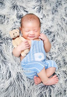 a baby is laying down with a teddy bear