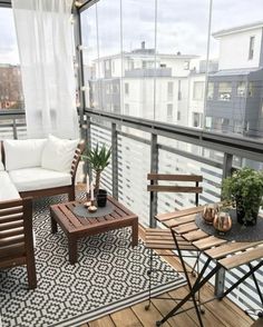 a balcony with wooden furniture and white curtains on the windowsills is decorated with potted plants