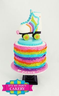 a colorful cake with roller skates on it's top and the words, it's my party cakery