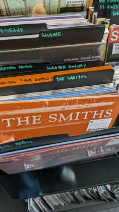 there are many records stacked on top of each other in this store display case with the words, the smiths