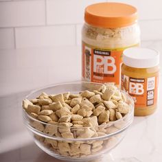 two jars of peanut butter next to a bowl of dog food