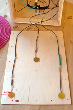 an electronic device with wires attached to it on a wooden surface next to a straw hat