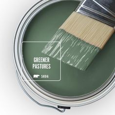 a green paint can with a brush in it and the words sparkling emerald on top