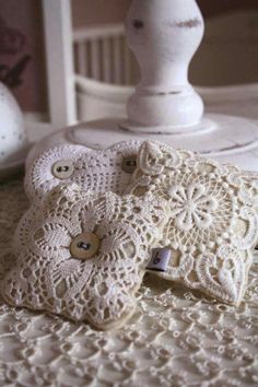 two white crocheted pillows sitting on top of a bed