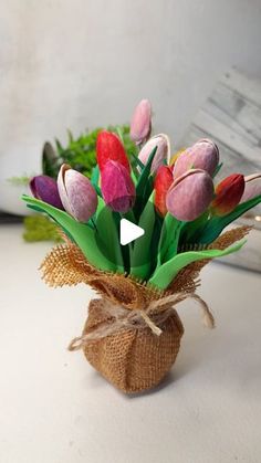 a vase filled with pink and red tulips on top of a table