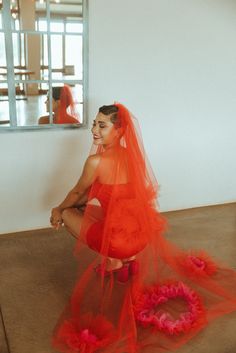 a woman sitting on the floor in a red dress