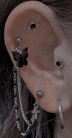 a close up of a person's ear with chains and piercings on it