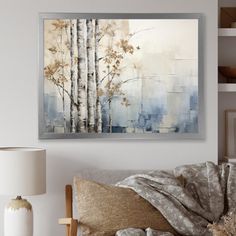 a painting hanging on the wall above a couch in a room with pillows and lamps