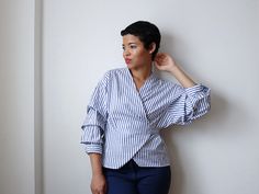 a woman leaning against a wall with her hand on her head and looking off to the side