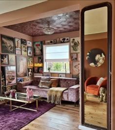 a living room filled with furniture and lots of pictures on the wall next to a window