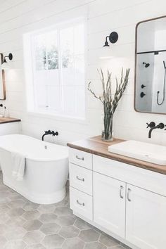 a white bathroom with two sinks and a bathtub