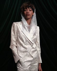 a woman in a white suit with a veil on her head