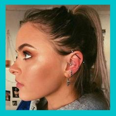 a woman wearing ear piercings and looking off into the distance