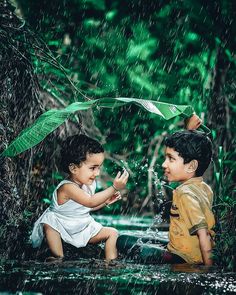 two children playing in the rain with an umbrella