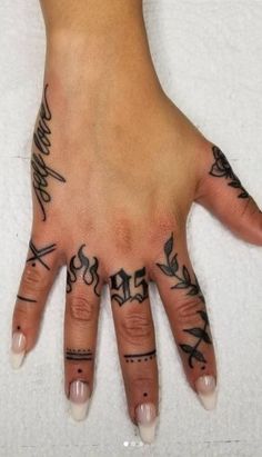 a woman's hand with tattoos on it and some writing on the palm area