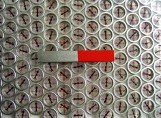 a close up of a metal grate with circles and red marker on the side