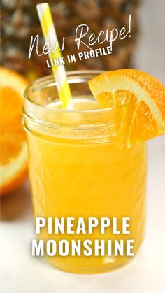 a pineapple smoothie in a mason jar with a straw and orange slices on the rim