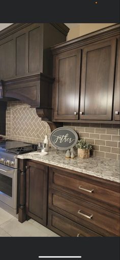 a kitchen with dark wood cabinets and white tile backsplash, stainless steel appliances