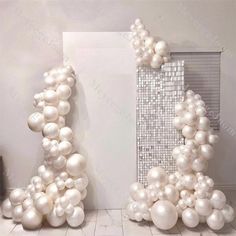 balloons are arranged in the shape of an eiffel tower with white and silver balls