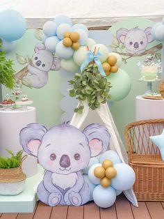 there is a birthday party with balloons and stuffed animals on the table, including a koala bear