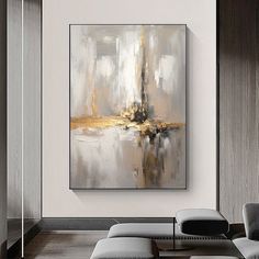 an abstract painting hangs on the wall next to a couch and ottoman in a modern living room