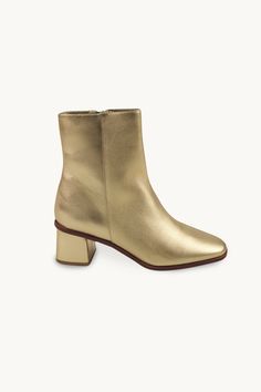 These ankle boots are crafted from high-quality leather in a metallic gold hue. They feature a side zipper closure, a low heel, and a sleek design. Designed for a bold and stylish look. Use our virtual size assistant to find your perfect fit. Unlock Screen, Gold Boots, Metallic Boots, Ankle Heels, Tiny Cottons, High Quality Leather, Metallic Gold, Low Heels, Sleek Design