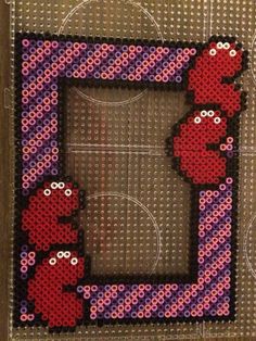 a cross stitch picture frame with the sesame characters on it and an image of two red birds