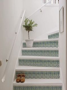 the stairs are decorated with blue and white tiles, along with a potted plant