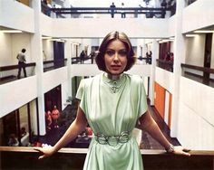 a woman in a green dress standing on a balcony