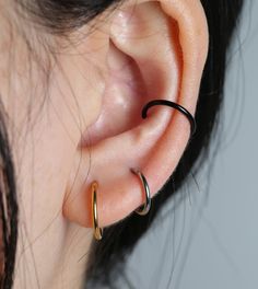 a close up of a person's ear with two rings on it