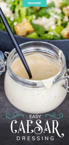 a salad with dressing in a jar and the words easy caesar dressing on it are shown