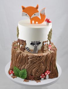 a three tiered cake decorated with woodland animals