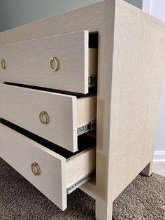 two drawers are open on the side of a dresser in a room with carpeted flooring