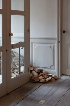 a pile of wood sitting on top of a wooden floor in front of a door