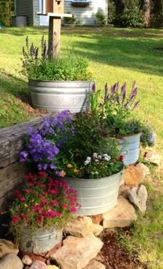 three flower pots sitting on top of a pile of rocks