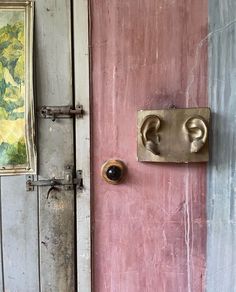 an old door with two knobs and a painting on the wall