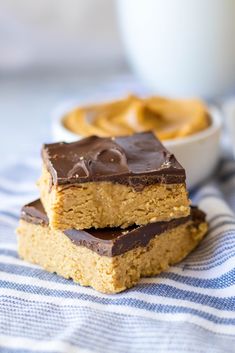 two pieces of chocolate peanut butter bars on a blue and white towel