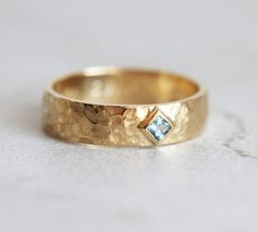 a gold ring with a blue diamond on it