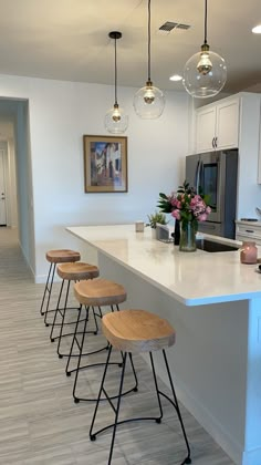 a kitchen island with four stools in front of it