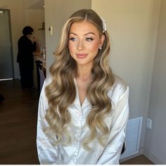 a woman with long blonde hair wearing a white shirt and pearled headpieces