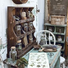 an old wooden shelf filled with jars and other items on top of a blue table