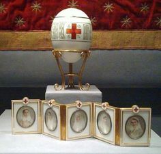 an egg is on display with four framed pictures in front of the eggshells