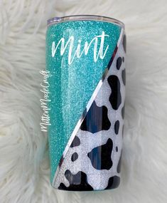 a blue and white tumbler sitting on top of a fur covered floor with the words mintt printed on it