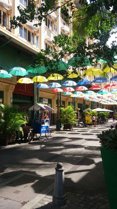 an outdoor market with umbrellas hanging from the ceiling