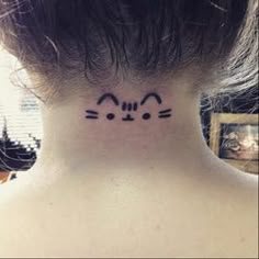 a woman's neck with a cat face tattoo on her left side ribcage