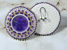 a pair of earrings sitting on top of a marble counter next to a white plate