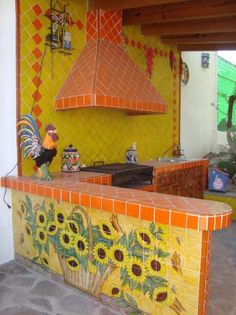 an outdoor kitchen with sunflowers painted on the counter and tile backsplash