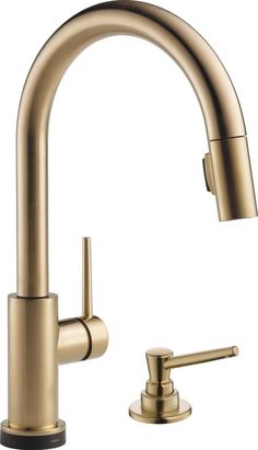 a brass colored kitchen faucet with two handles